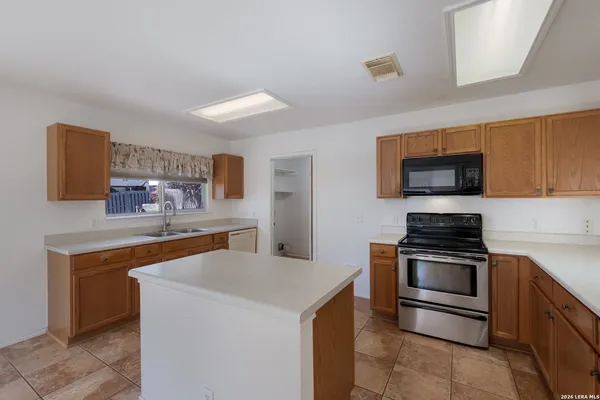 a kitchen with stainless steel appliances granite countertop a stove top oven a sink and a microwave