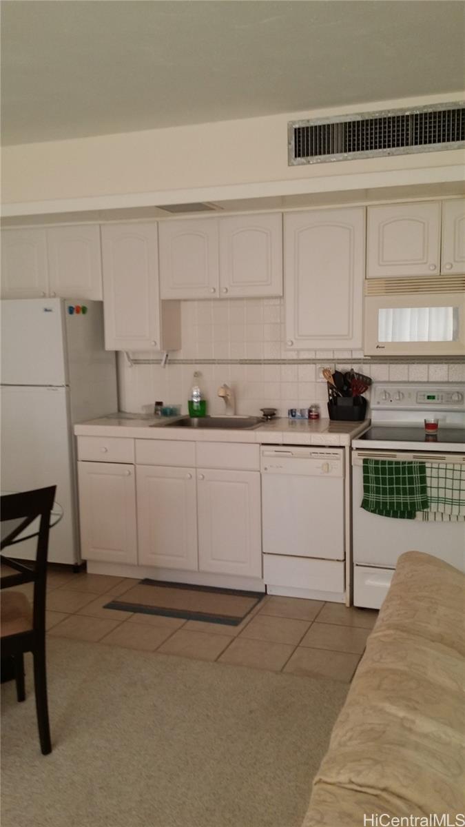 a utility room with stainless steel appliances wooden cabinets and a sink