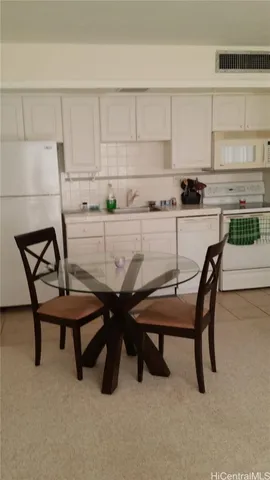 a kitchen with a table chairs and a refrigerator