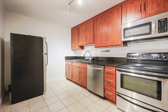 a kitchen with stainless steel appliances granite countertop a refrigerator stove and sink