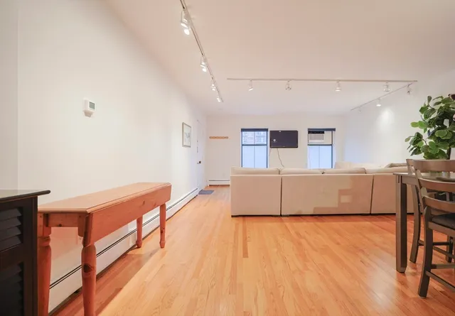 a living room with stainless steel appliances wooden floors and view living room