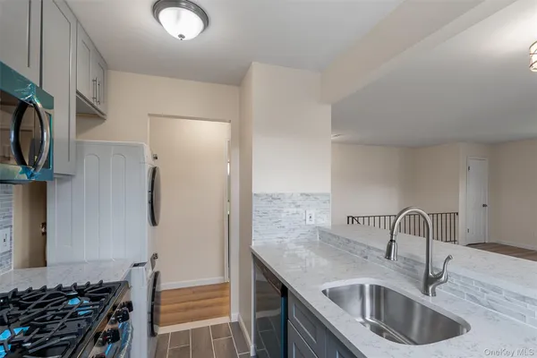 a kitchen with stainless steel appliances granite countertop a sink and a refrigerator