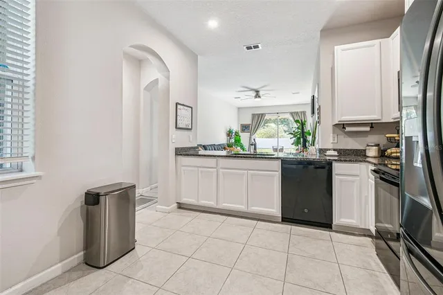a kitchen with stainless steel appliances a dining table chairs and cabinets