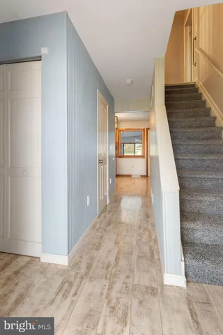 a view of a hallway with wooden floor and staircase