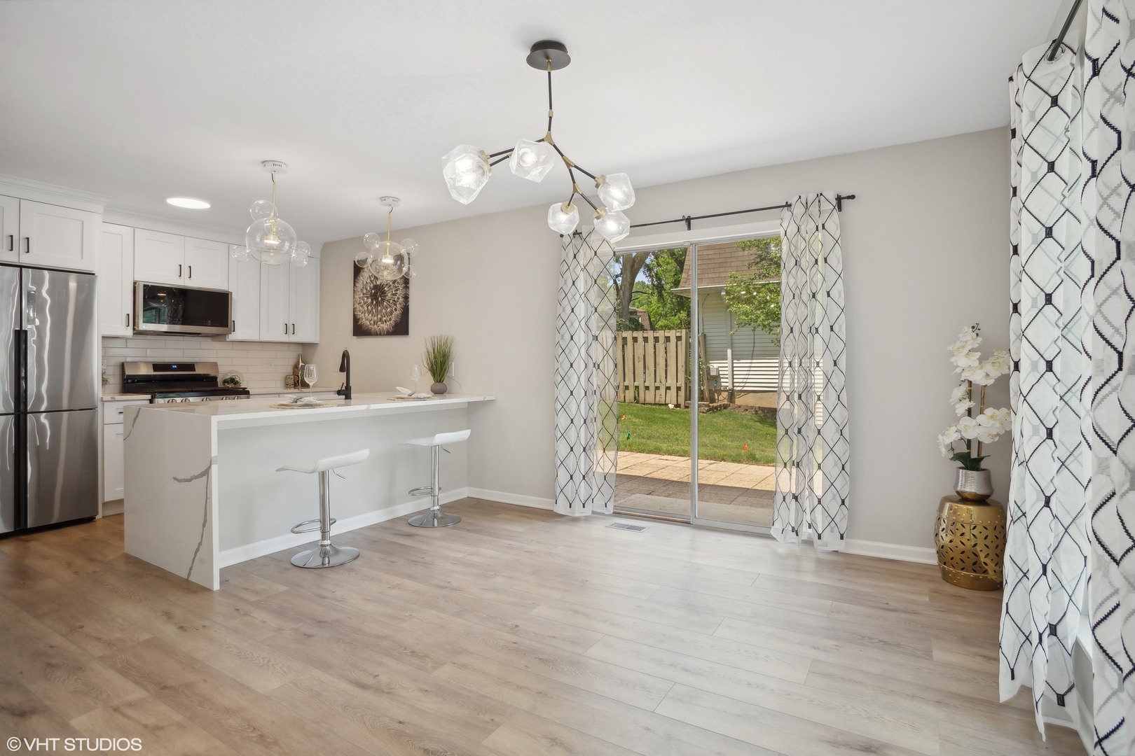 16 Forest Lane Cary, IL 60013 - Photo 7 of 18 a kitchen with stainless steel appliances a stove a refrigerator a sink a oven with white cabinets and wooden floor