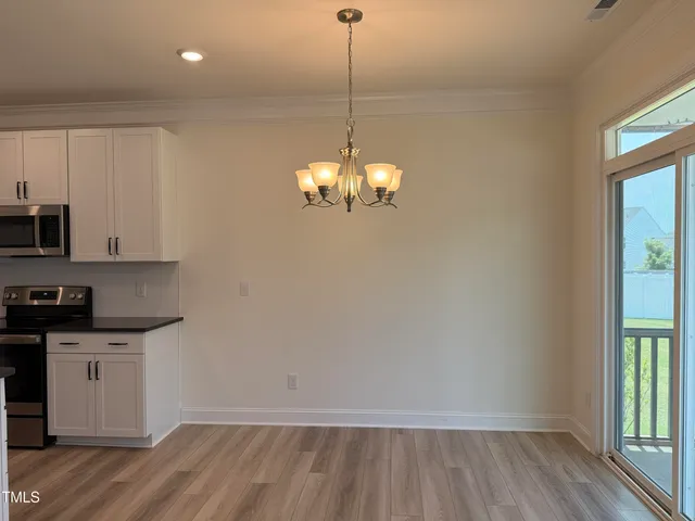 a kitchen with kitchen island granite countertop white cabinets and refrigerator