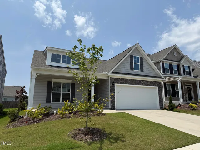 a front view of a house with a yard and garage