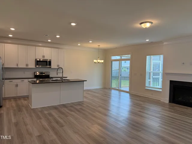 an empty room with wooden floor and fireplace