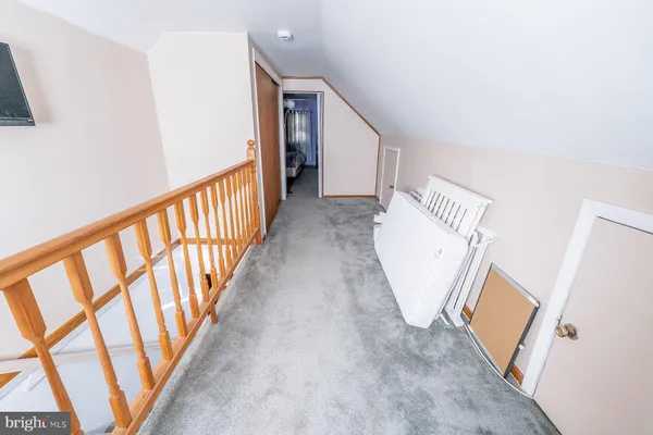 a view of a hallway with wooden floor and stairs