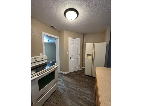 a view of a kitchen from a hallway