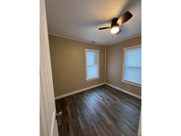 a view of an empty room with wooden floor