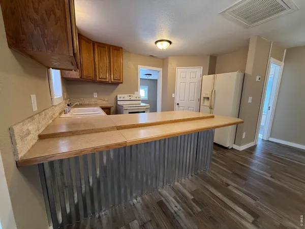 a kitchen with stainless steel appliances wooden floor sink stove and cabinets