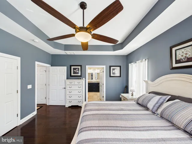 a spacious bedroom with a bed and a ceiling fan