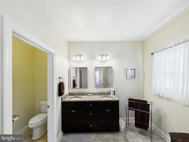 a bathroom with a toilet a sink and mirror