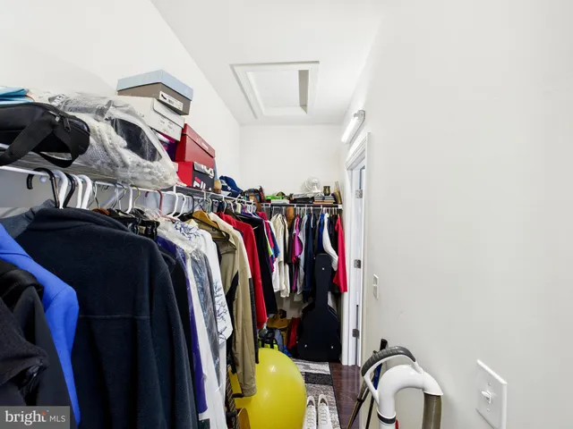 a view of walk in closet with clothes and shoes
