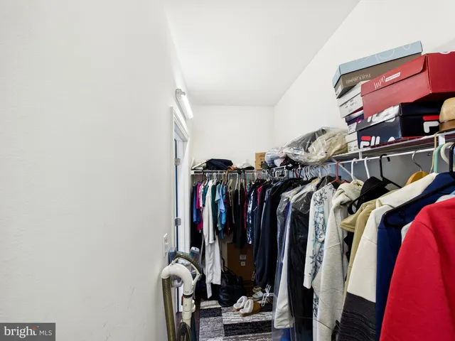 a view of walk in closet with clothes