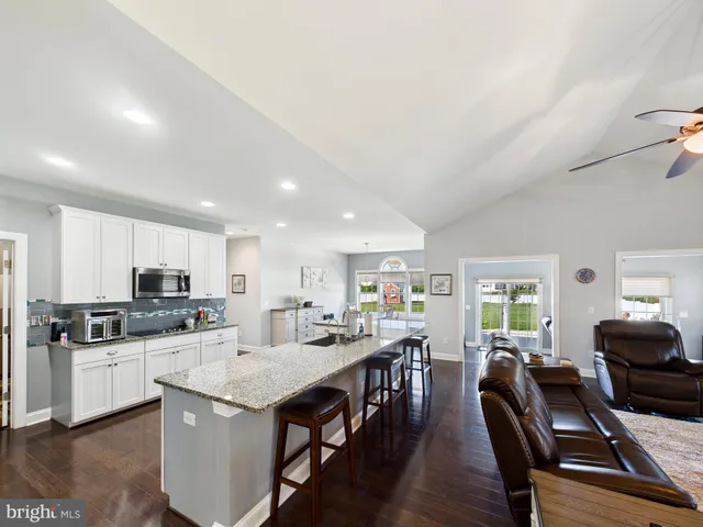a kitchen with stainless steel appliances kitchen island granite countertop a stove a sink a dining table and chairs