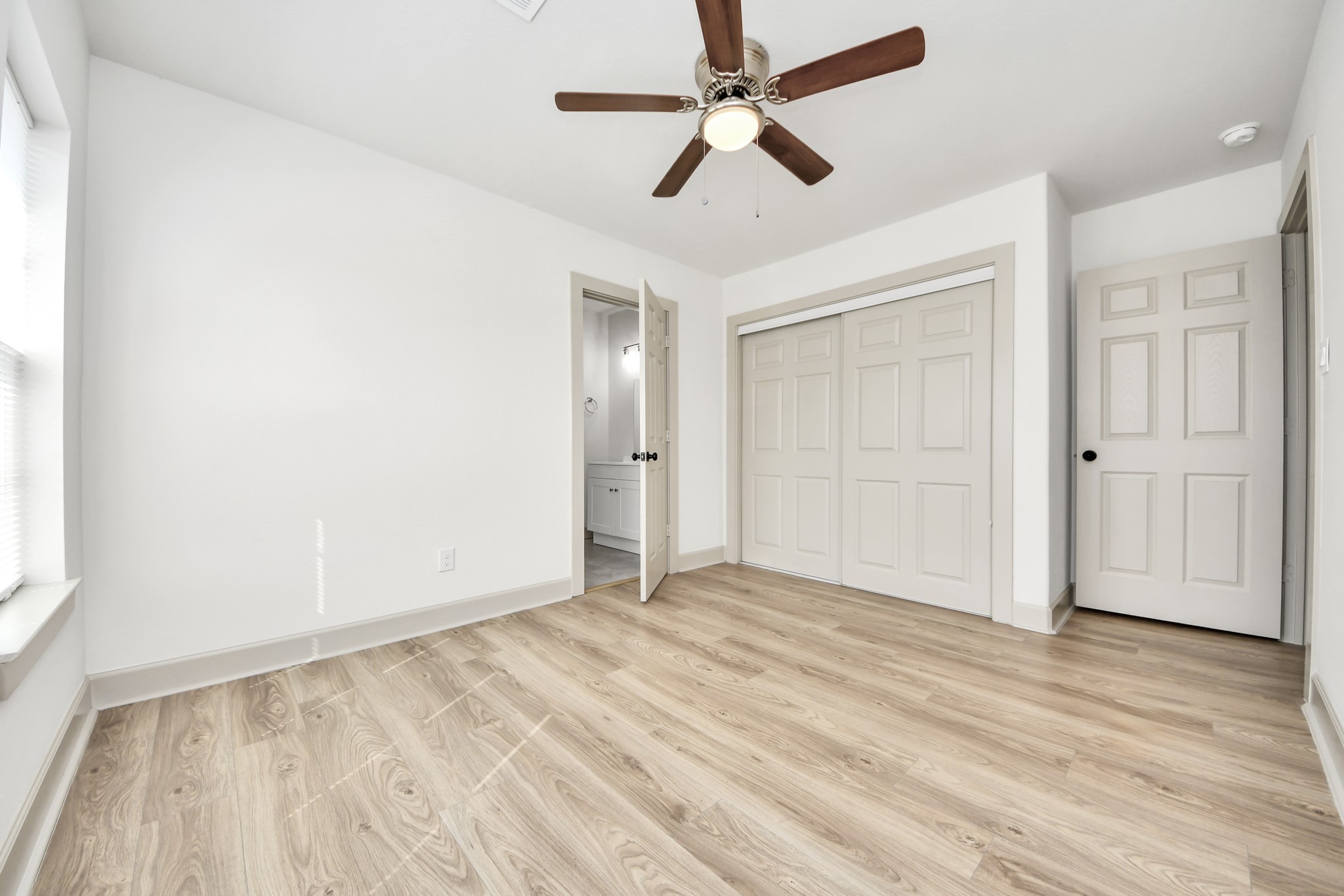 2919 Rosedale Street, Unit B Houston, TX 77004 - Photo 24 of 35 an empty room with wooden floor ceiling fan and windows