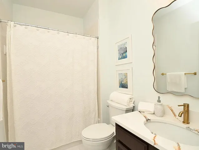 a bathroom with a sink vanity mirror and toilet
