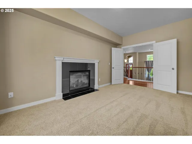 a view of an empty room with a fireplace and a window