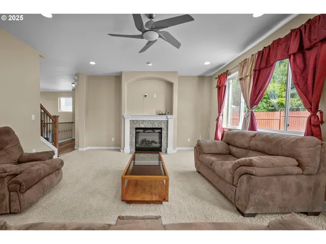 a living room with furniture a large window and a fireplace