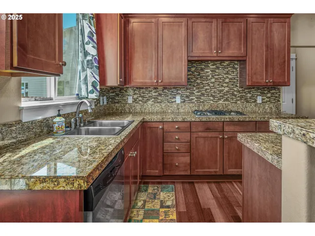 a kitchen with granite countertop a sink stove and cabinets