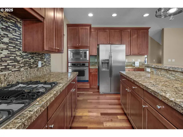 a kitchen with wooden cabinets and stainless steel appliances