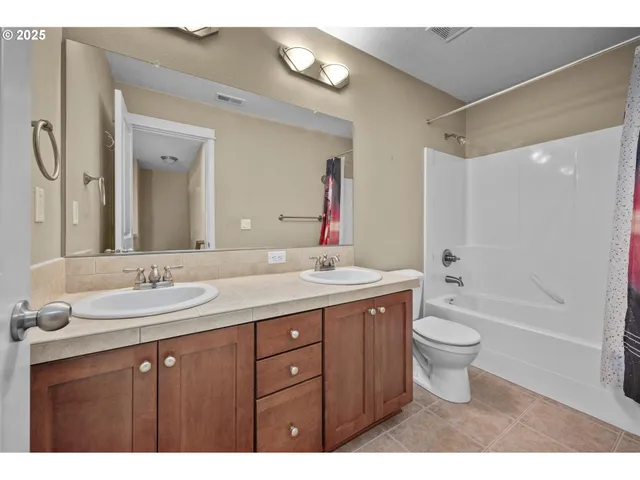 a bathroom with a granite countertop sink toilet a large mirror a bathtub and shower
