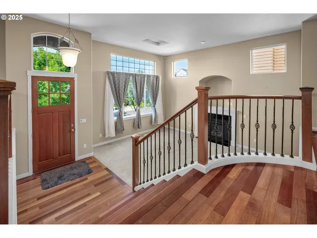 a view of a hallway with wooden floor and stairs