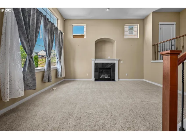 a view of empty room with fireplace and fan