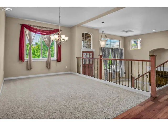 a view of empty room with floor to ceiling window and dining room