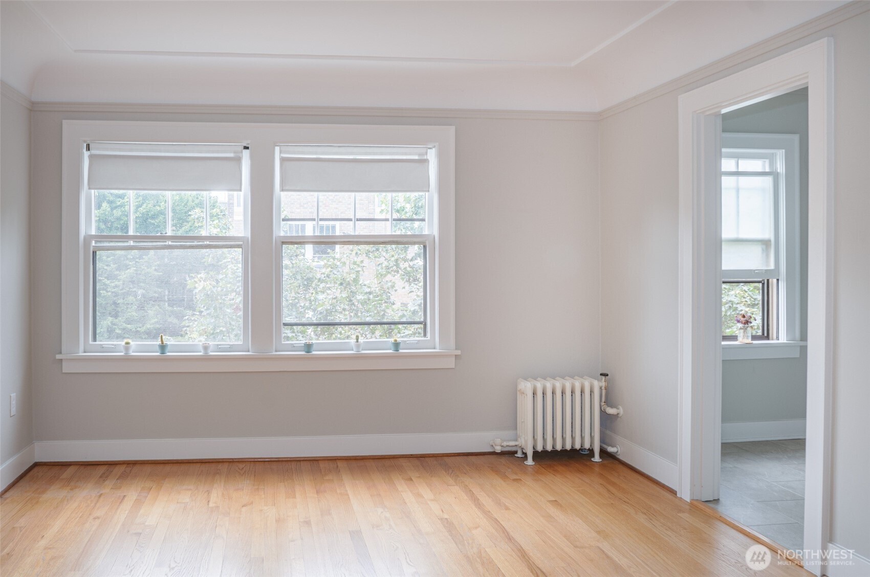 1605 East Olive Street, Unit 307 Seattle, WA 98122 - Photo 2 of 21 an empty room with wooden floor and windows