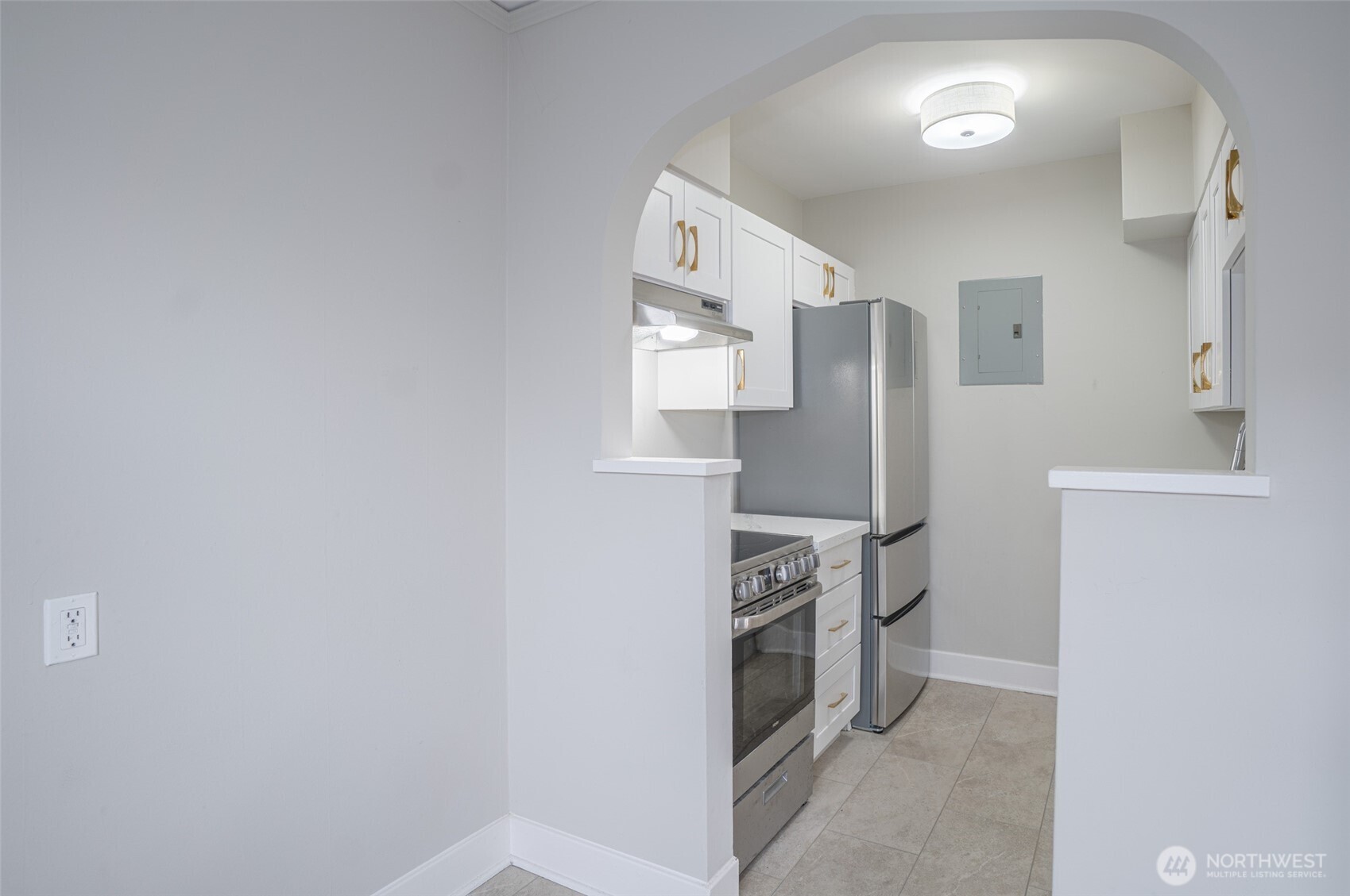 1605 East Olive Street, Unit 307 Seattle, WA 98122 - Photo 6 of 21 a kitchen with stainless steel appliances white cabinets and a stove
