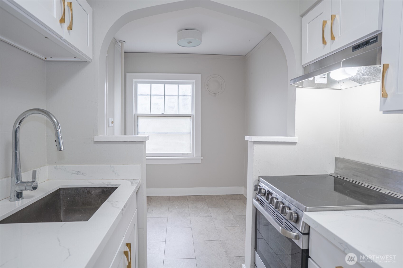 1605 East Olive Street, Unit 307 Seattle, WA 98122 - Photo 9 of 21 a kitchen with granite countertop a sink and a stove top oven