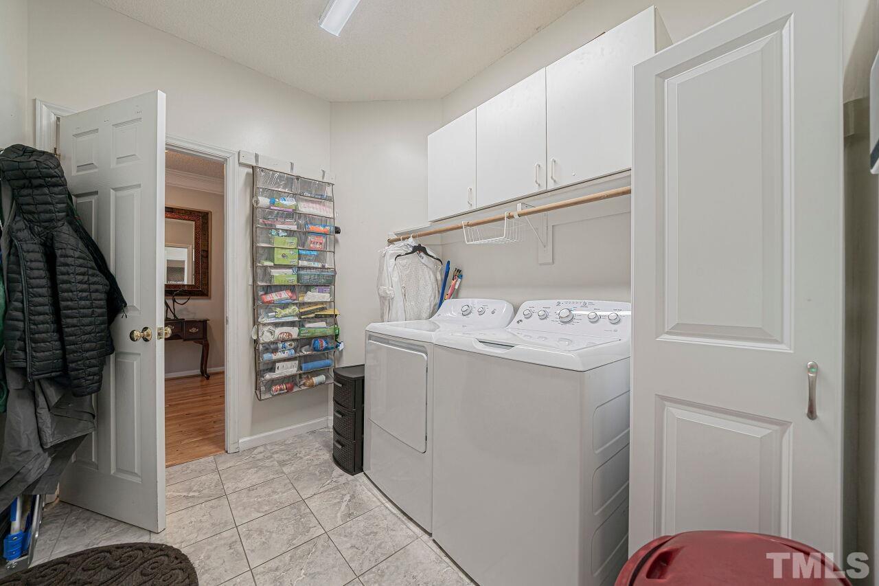 6901 Brigmore Court Raleigh, NC 27617 - Photo 17 of 25 a utility room with cabinets washer and dryer