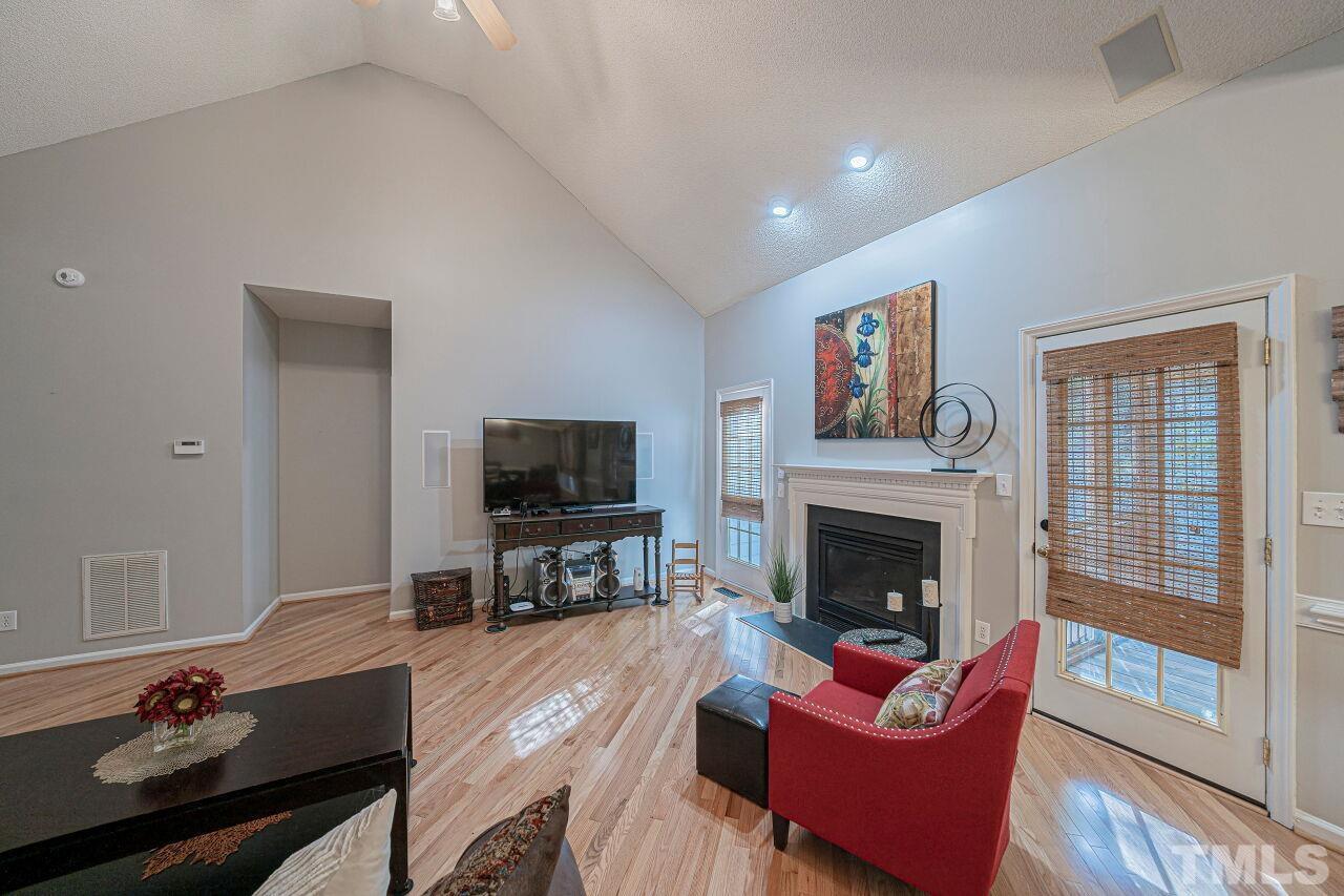 6901 Brigmore Court Raleigh, NC 27617 - Photo 8 of 25 a living room with furniture a flat screen tv and a fireplace