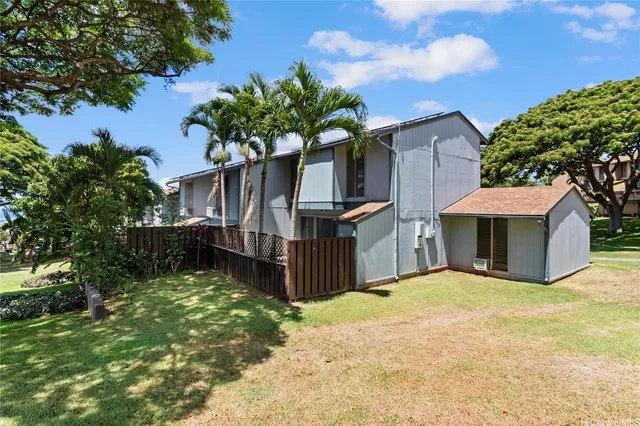 a front view of a house with a garden and tree