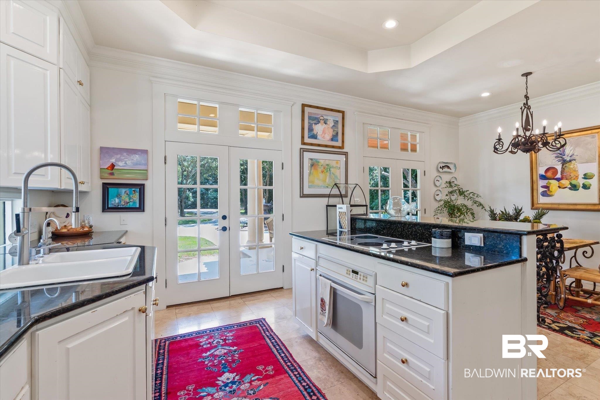 6341 Raintree Road Fairhope, AL 36532 - Photo 10 of 40 Kitchen with white oven, french doors, a tray ceiling, light tile patterned floors, and white cabinets