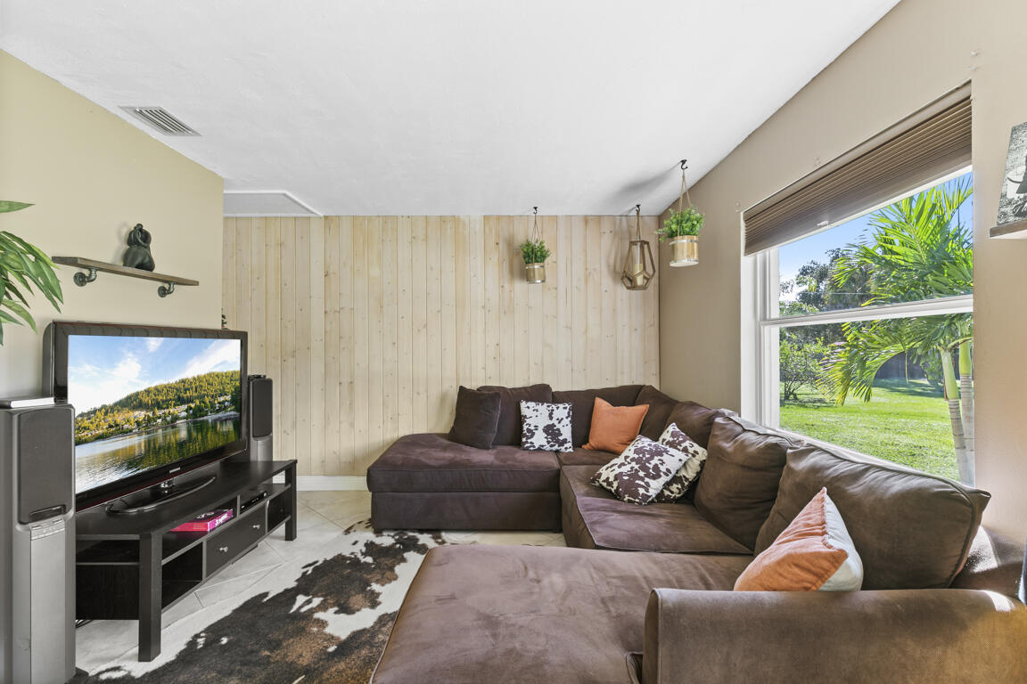 640 27th Street Southwest Naples, FL 34117 - Photo 2 of 37 a living room with furniture a window and a flat screen tv