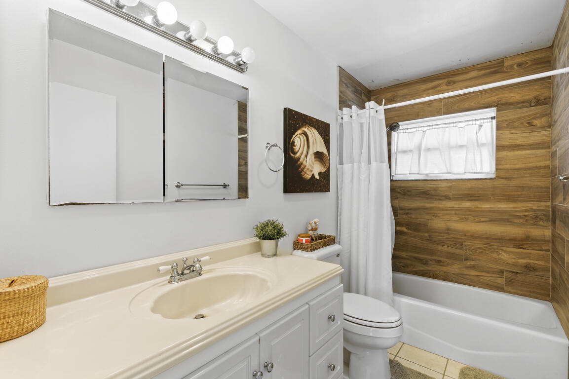 640 27th Street Southwest Naples, FL 34117 - Photo 13 of 37 a bathroom with a sink a toilet and shower curtain