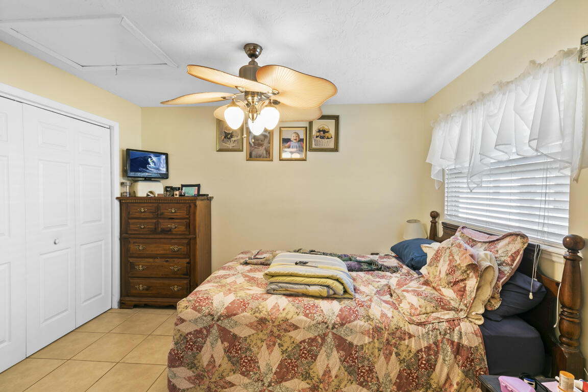 640 27th Street Southwest Naples, FL 34117 - Photo 27 of 37 a bedroom with a bed and a chandelier