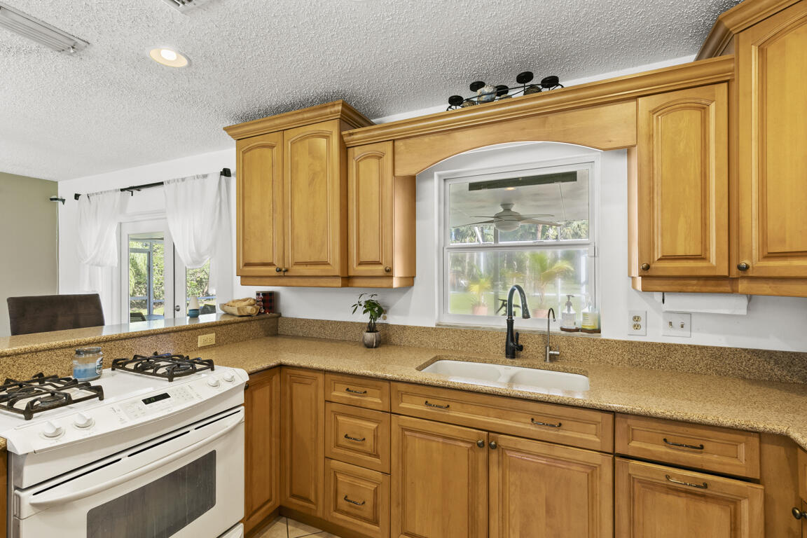 640 27th Street Southwest Naples, FL 34117 - Photo 7 of 37 a kitchen with stainless steel appliances a sink stove and cabinets