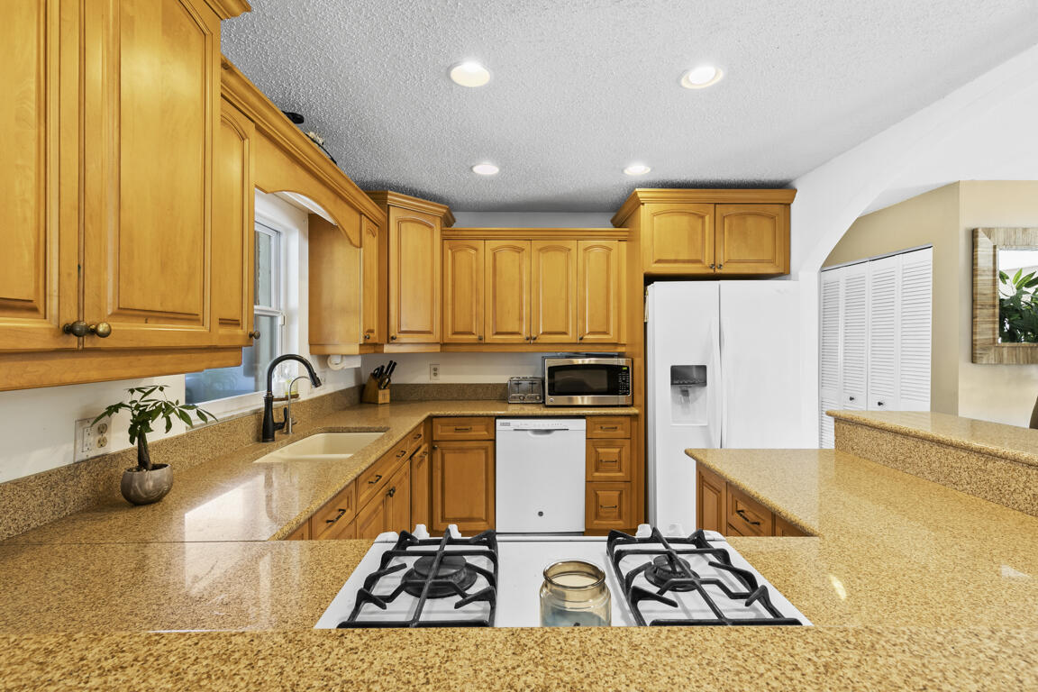 640 27th Street Southwest Naples, FL 34117 - Photo 8 of 37 a kitchen with stainless steel appliances a sink a stove a refrigerator cabinets and a counter top space