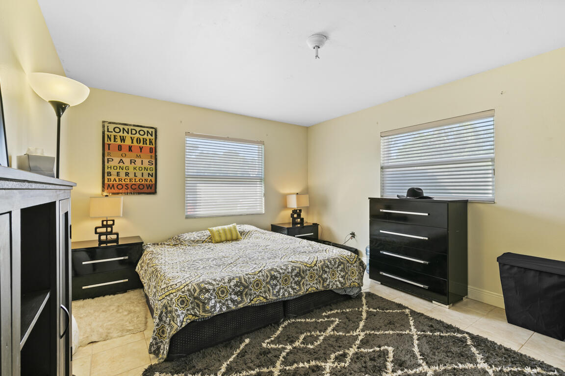 640 27th Street Southwest Naples, FL 34117 - Photo 10 of 37 a bedroom with a bed and a dresser with wooden floor