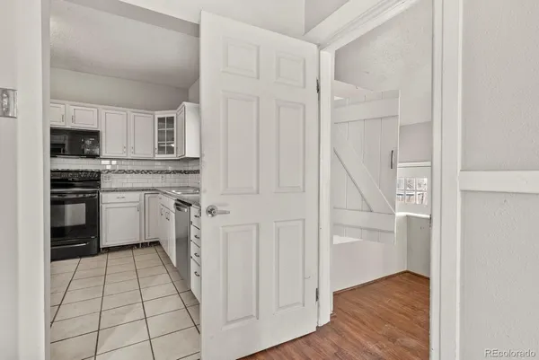 a kitchen with white cabinets and appliances
