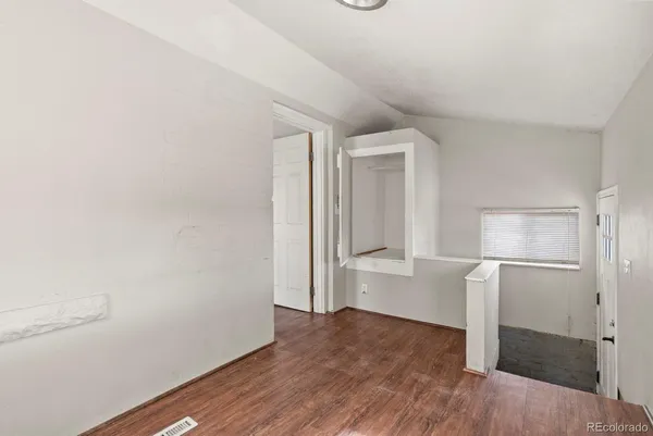 a view of empty room with wooden floor