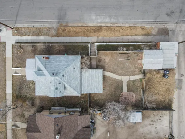 an aerial view of a house with a yard and mountain view in back