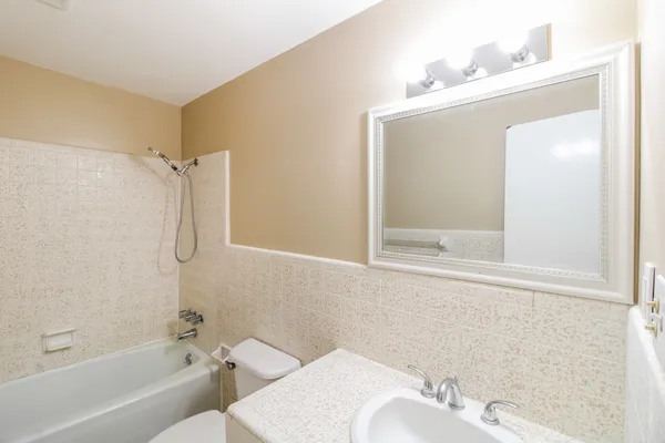 a bathroom with a bathtub shower sink vanity and toilet