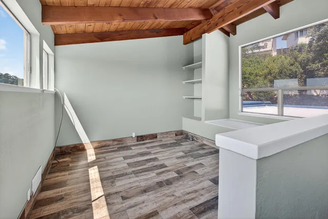 an empty room with wooden floor and door