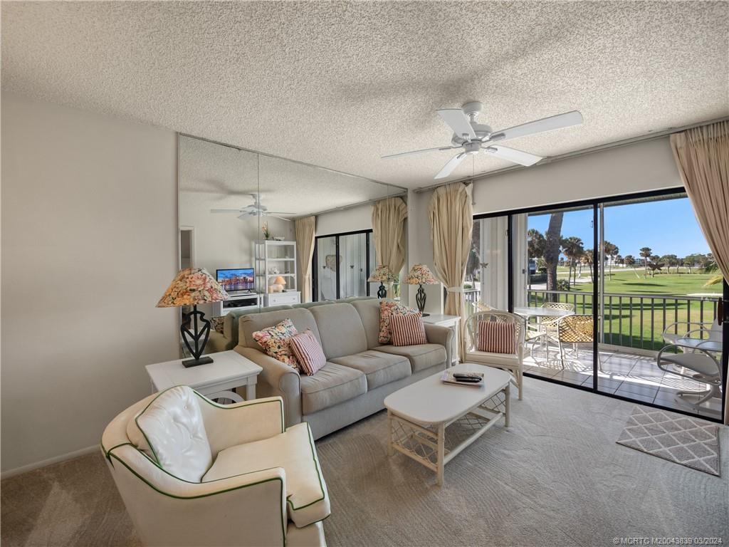 484 Northeast Plantation Road, Unit 4106 Jensen Beach, FL 34957 - Photo 3 of 15 a living room with furniture and a large window